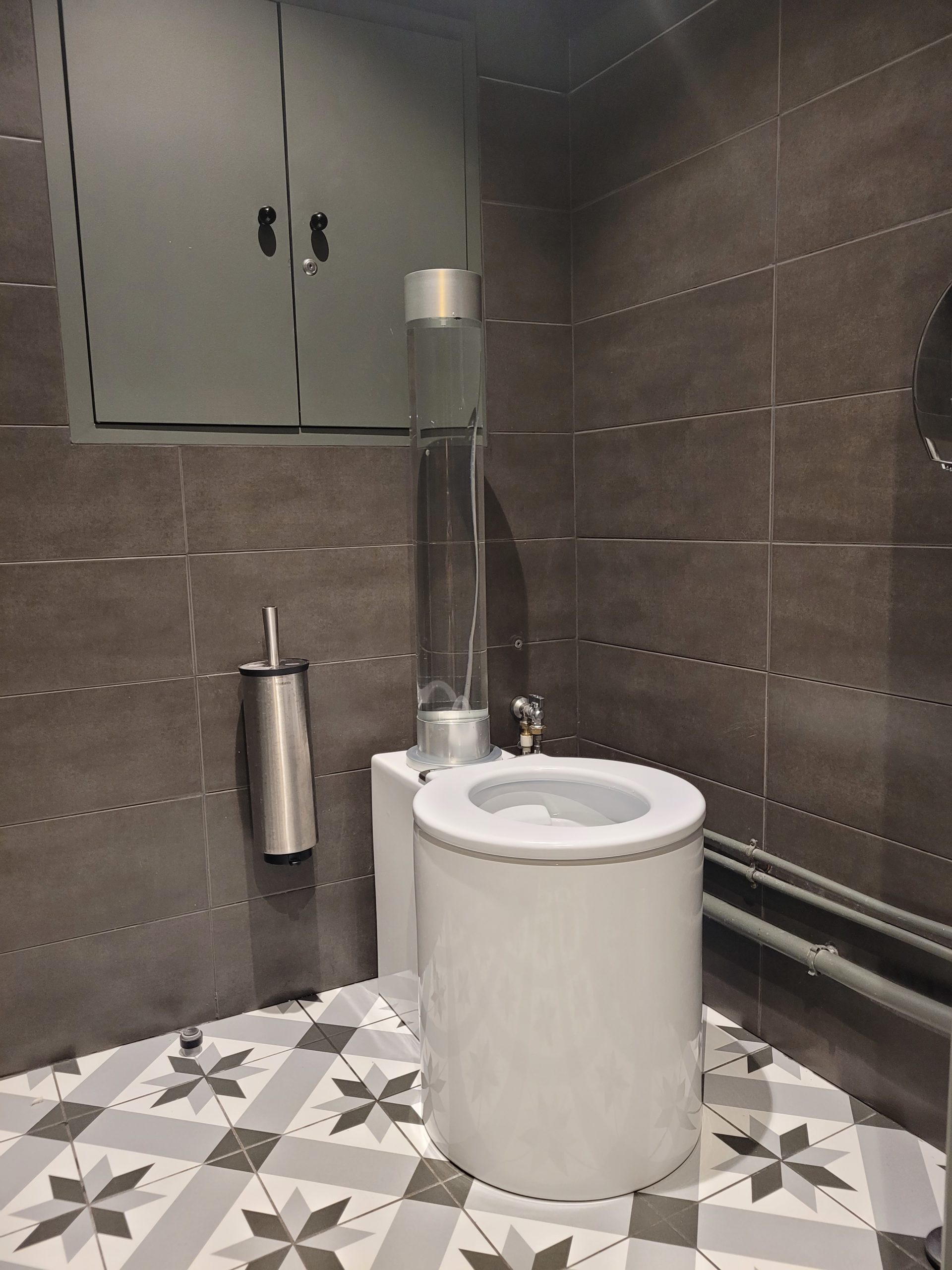 Photo d'une rénovation de wc de la marque trône sur un carrelage à motif gris et blanc